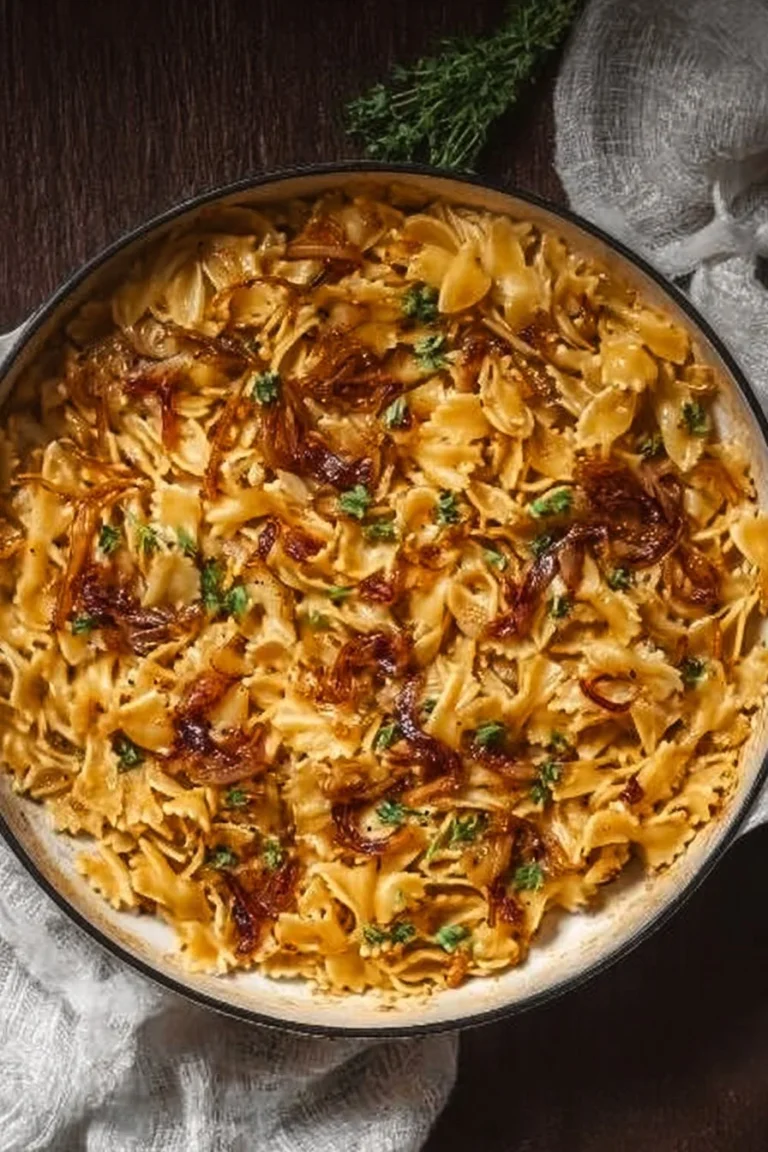 One pan caramelized onion pasta topped with herbs and cheese, ready to serve.