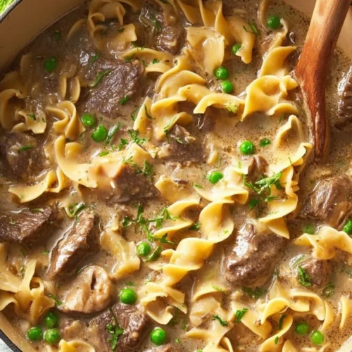 Bowl of Beef Stroganoff Soup garnished with herbs and served with bread