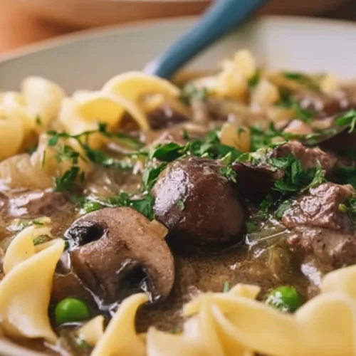 Delicious Beef Stroganoff Soup in a bowl with fresh herbs garnish.