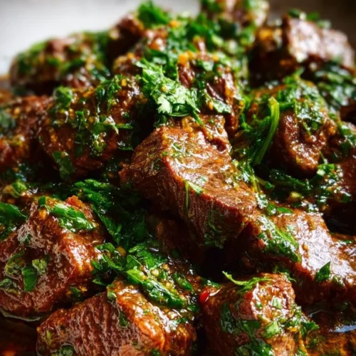 Plate of garlic butter beef bites garnished with herbs and spices