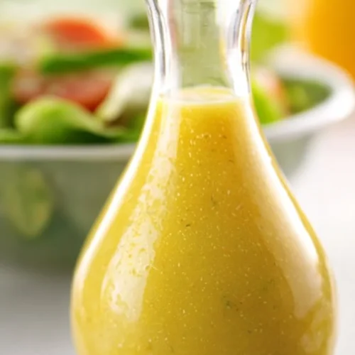 A bowl of fresh Caesar salad topped with creamy dressing and croutons.