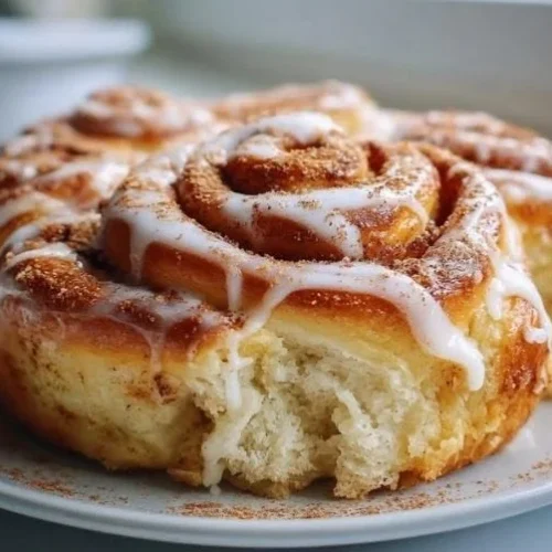 Freshly baked cinnamon roll focaccia topped with icing and cinnamon sugar