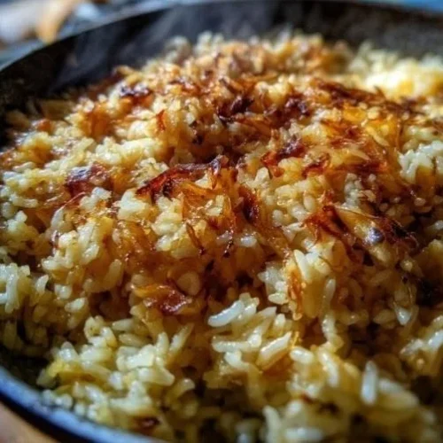 Creamy French onion rice dish topped with melted cheese and caramelized onions