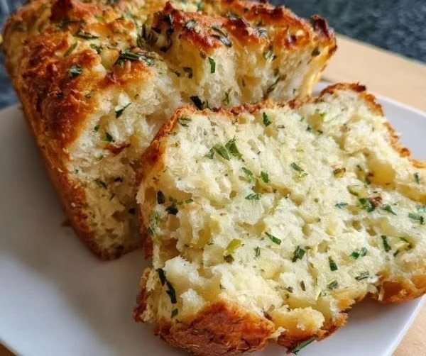 Freshly baked Garlic Herb Bread with herbs and garlic on a wooden board.