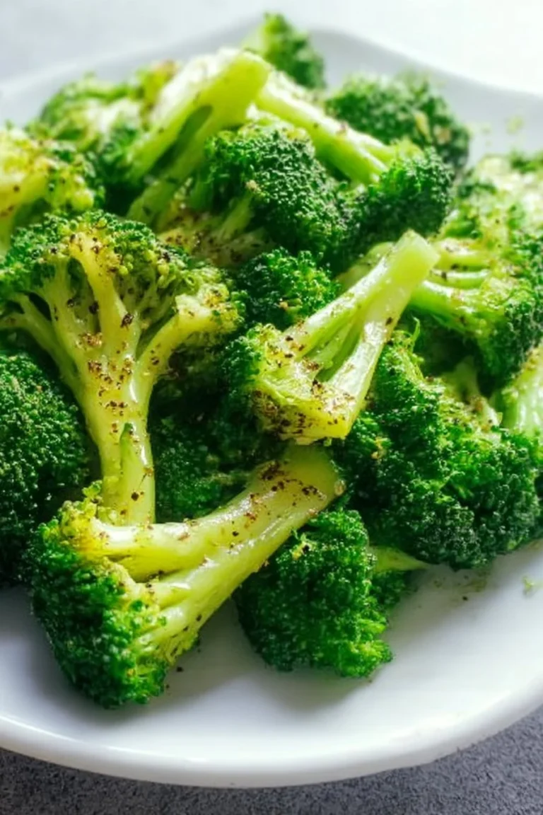 Plate of savory roasted broccoli drizzled with olive oil and spices