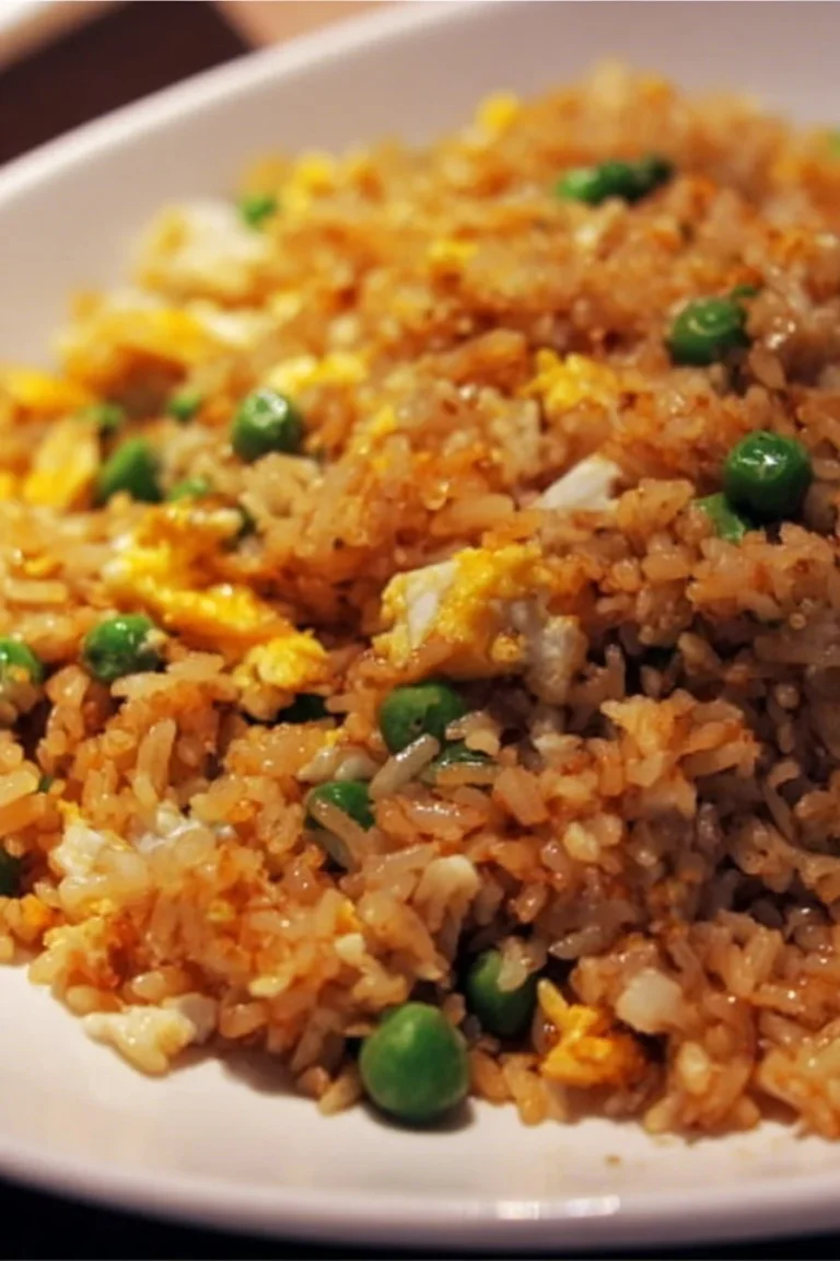 Delicious egg fried rice served in a bowl with vegetables and seasonings.