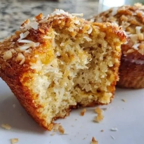Freshly baked Coconut Banana Crunch Muffins with coconut flakes and banana slices