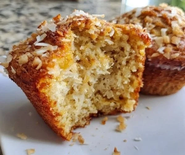 Freshly baked Coconut Banana Crunch Muffins with coconut flakes and banana slices