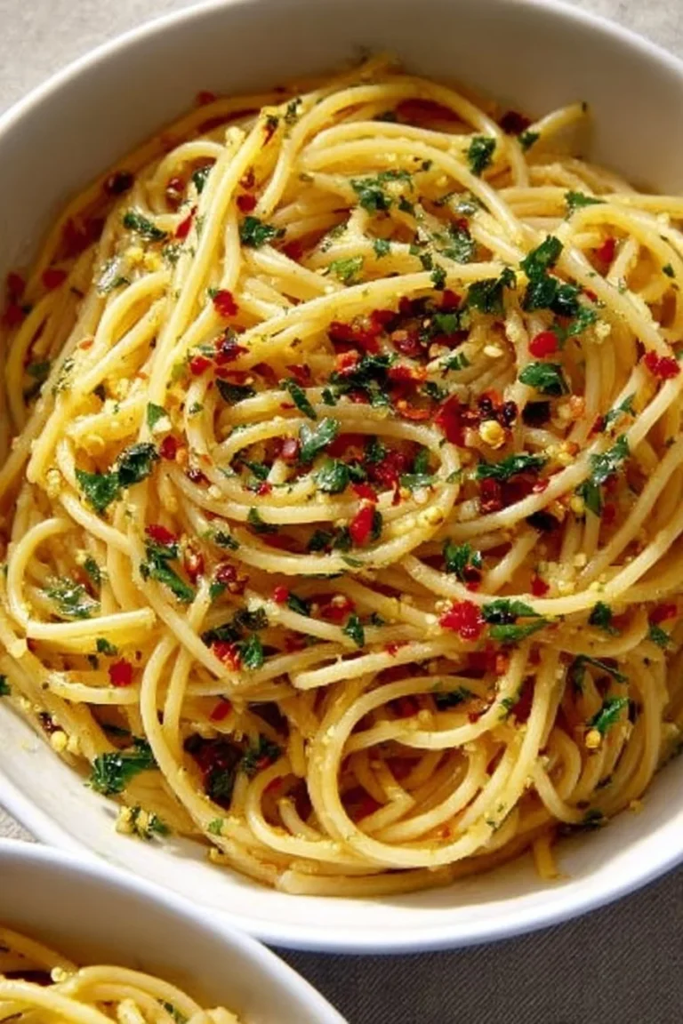 Plate of Garlic Oil Pasta garnished with fresh parsley and Parmesan cheese.